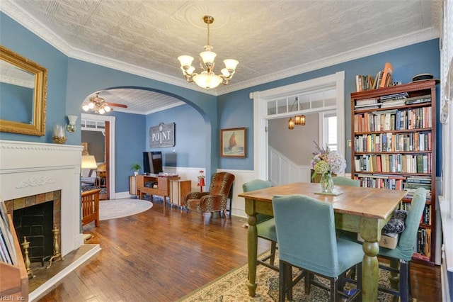 122 S Willard Ave, Hampton, VA 23663 - dining space with arched walkways, a chandelier, a fireplace with raised hearth, wood finished floors, and ornamental molding