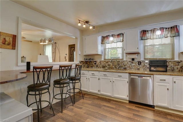 6285 Buckley Hall Rd, Cobbs Creek, VA 23035 - kitchen featuring dishwasher, white cabinets, dark wood-style flooring, a kitchen breakfast bar, and tasteful backsplash