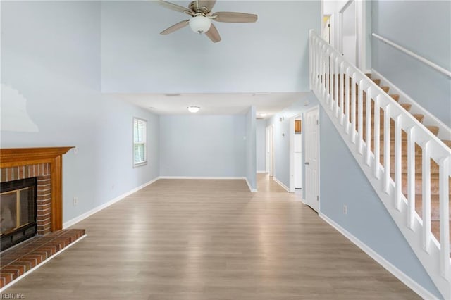 1117 Tibbetstown Ct, Virginia Beach, VA 23454 - unfurnished living room featuring ceiling fan, wood finished floors, a fireplace, a towering ceiling, and stairway