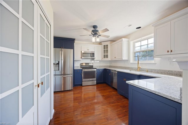 3015 Beech Grove Ln, Suffolk, VA 23435 - kitchen with appliances with stainless steel finishes, blue cabinetry, light stone counters, ceiling fan, and white cabinetry