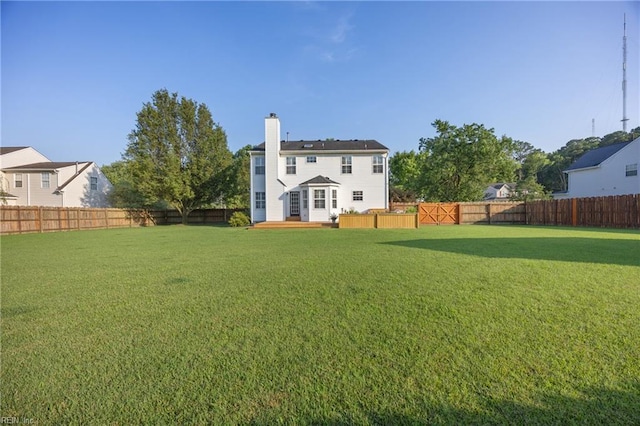 3015 Beech Grove Ln, Suffolk, VA 23435 - rear view of property with a fenced backyard, a chimney, and a deck