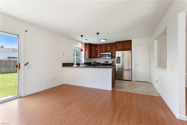 5405 Kiawah Ct, Virginia Beach, VA 23462 - kitchen with appliances with stainless steel finishes, dark countertops, a peninsula, light wood finished floors, and pendant lighting