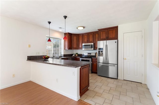5405 Kiawah Ct, Virginia Beach, VA 23462 - kitchen featuring appliances with stainless steel finishes, a peninsula, dark countertops, and pendant lighting