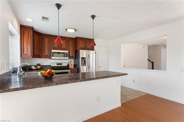 5405 Kiawah Ct, Virginia Beach, VA 23462 - kitchen with appliances with stainless steel finishes, a peninsula, decorative light fixtures, light wood-style flooring, and recessed lighting