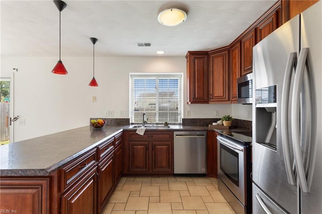 5405 Kiawah Ct, Virginia Beach, VA 23462 - kitchen with appliances with stainless steel finishes, dark countertops, a peninsula, decorative light fixtures, and light stone finish floors