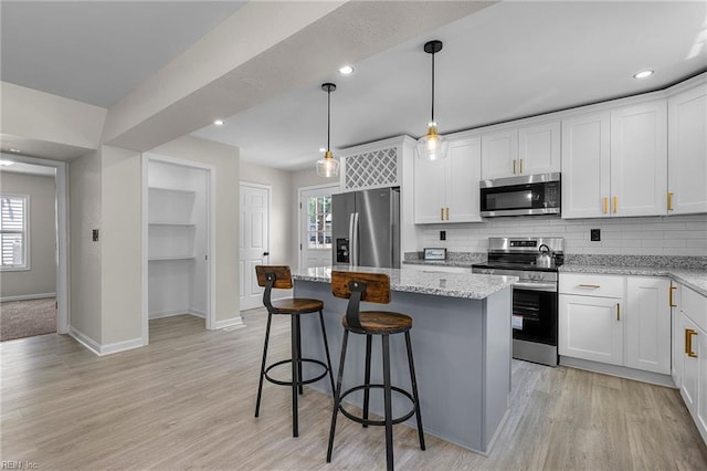 21 Rodgers Pl, Portsmouth, VA 23702 - kitchen with stainless steel appliances, a center island, backsplash, white cabinetry, and recessed lighting