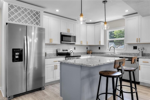 21 Rodgers Pl, Portsmouth, VA 23702 - kitchen featuring appliances with stainless steel finishes, white cabinetry, light wood-type flooring, a center island, and recessed lighting