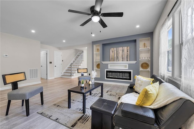 21 Rodgers Pl, Portsmouth, VA 23702 - living room with stairs, a glass covered fireplace, light wood-style floors, recessed lighting, and a ceiling fan
