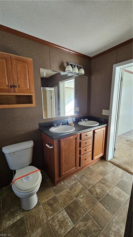 4371 Providence Rd, Hayes, VA 23072 - full bathroom with double vanity, a textured ceiling, and crown molding