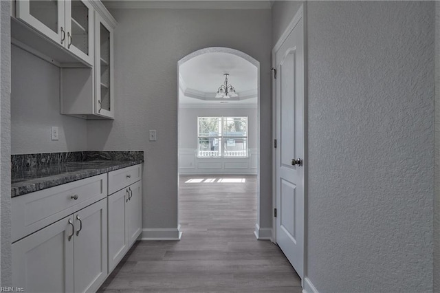 115 Pescara Ln, Newport News, VA 23601 - kitchen featuring crown molding, a textured wall, wood finished floors, glass insert cabinets, and white cabinetry