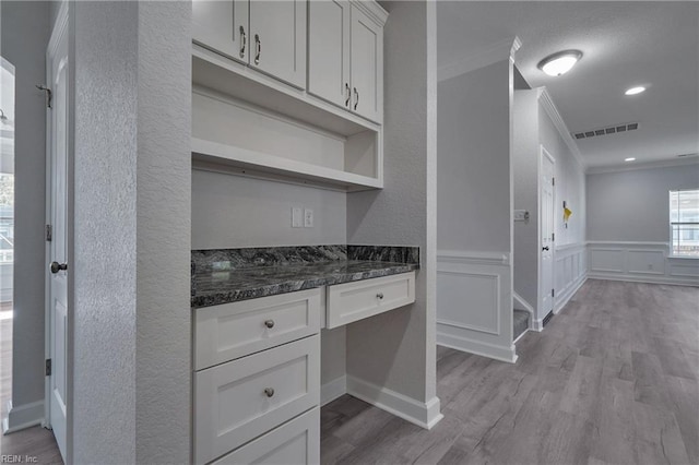 115 Pescara Ln, Newport News, VA 23601 - kitchen with ornamental molding, built in desk, wood finished floors, white cabinetry, and a wainscoted wall