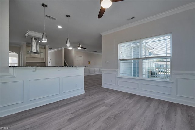 115 Pescara Ln, Newport News, VA 23601 - kitchen with a ceiling fan, island range hood, crown molding, a decorative wall, and dark stone counters