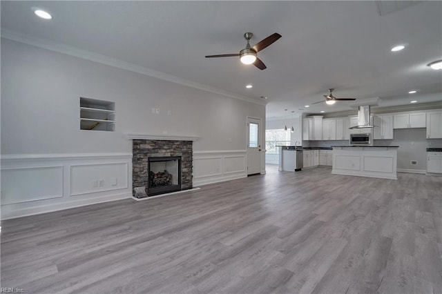 115 Pescara Ln, Newport News, VA 23601 - unfurnished living room featuring a ceiling fan, ornamental molding, a decorative wall, a fireplace, and recessed lighting
