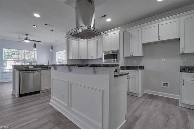 115 Pescara Ln, Newport News, VA 23601 - kitchen featuring appliances with stainless steel finishes, island range hood, a ceiling fan, white cabinets, and ornamental molding