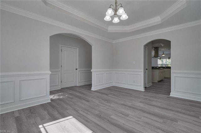 115 Pescara Ln, Newport News, VA 23601 - empty room with a chandelier, a tray ceiling, arched walkways, wood finished floors, and crown molding