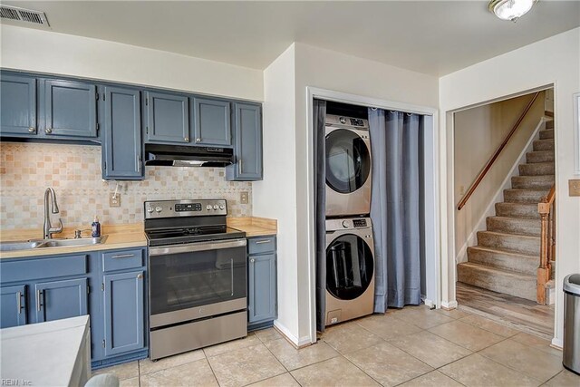 2561 Elon Dr, Virginia Beach, VA 23454 - kitchen featuring stainless steel electric range oven, under cabinet range hood, stacked washer and clothes dryer, and backsplash