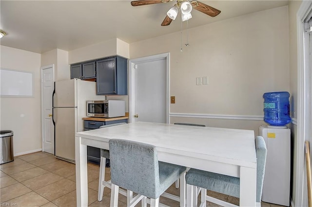 2561 Elon Dr, Virginia Beach, VA 23454 - kitchen with stainless steel microwave, freestanding refrigerator, ceiling fan, light tile patterned flooring, and a kitchen bar
