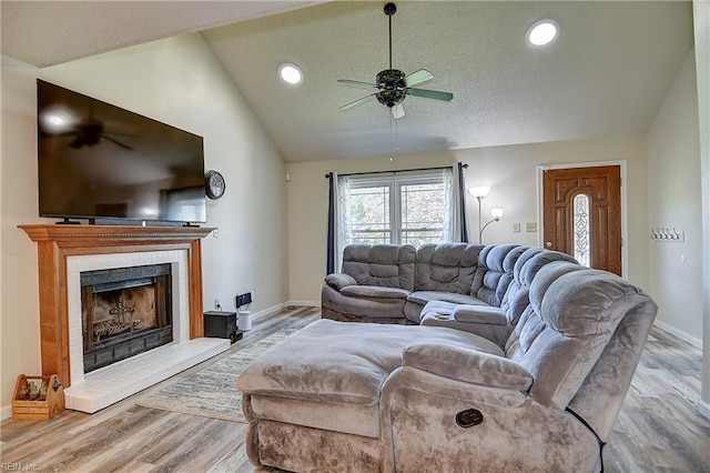 2561 Elon Dr, Virginia Beach, VA 23454 - living room with a ceiling fan, lofted ceiling, wood finished floors, a fireplace with raised hearth, and a textured ceiling