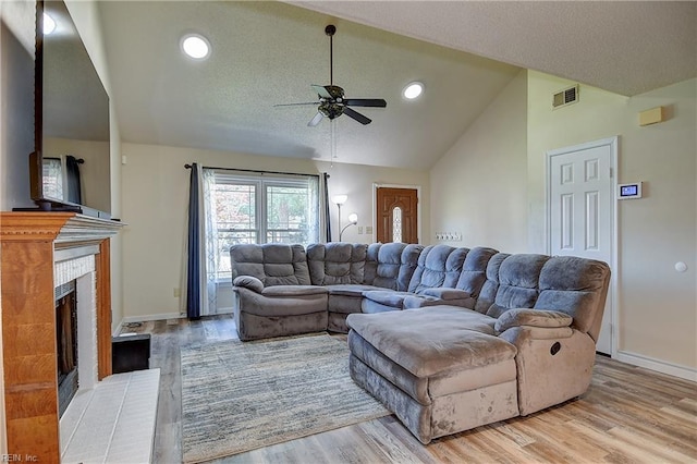2561 Elon Dr, Virginia Beach, VA 23454 - living area featuring vaulted ceiling, ceiling fan, light wood-style flooring, a textured ceiling, and a brick fireplace