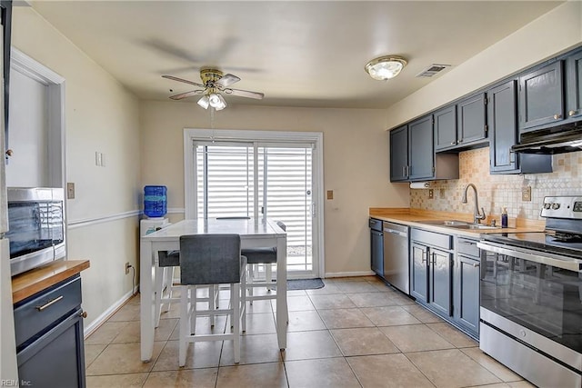 2561 Elon Dr, Virginia Beach, VA 23454 - kitchen featuring stainless steel appliances, under cabinet range hood, a ceiling fan, decorative backsplash, and light tile patterned floors