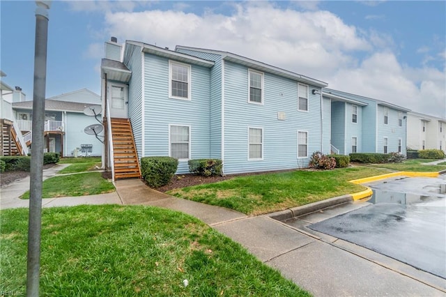 515 Wharf Ct, Virginia Beach, VA 23462 - view of side of property with stairs, a lawn, uncovered parking, and a residential view