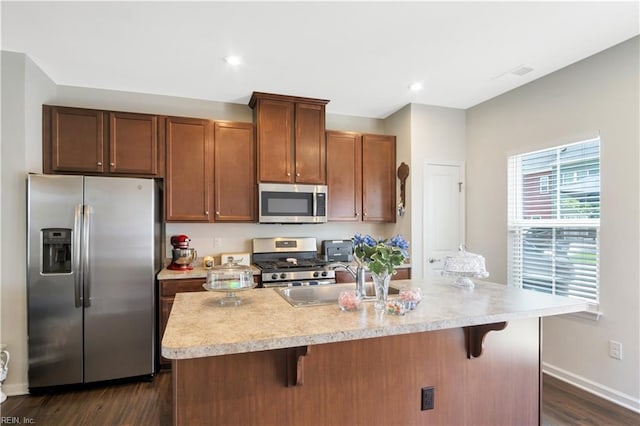 4315 Sconce, Williamsburg, VA 23188 - kitchen with stainless steel appliances, light countertops, a kitchen bar, dark wood finished floors, and recessed lighting