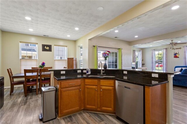 5212 Moreland St Unit 450, Suffolk, VA 23435 - kitchen with stainless steel dishwasher, open floor plan, brown cabinetry, a kitchen island with sink, and dark stone countertops