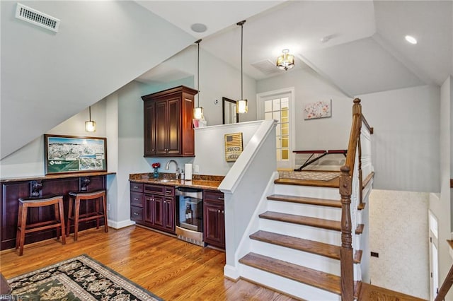 201 Glebe Spring Ln, Yorktown, VA 23693 - stairway featuring wet bar, wood finished floors, and vaulted ceiling