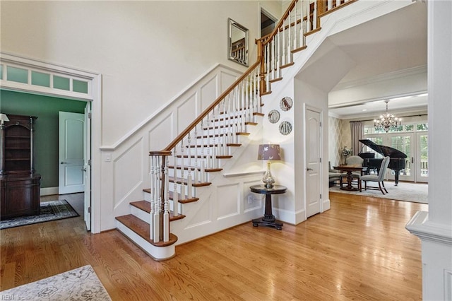 201 Glebe Spring Ln, Yorktown, VA 23693 - staircase with a decorative wall, wood finished floors, a chandelier, and crown molding