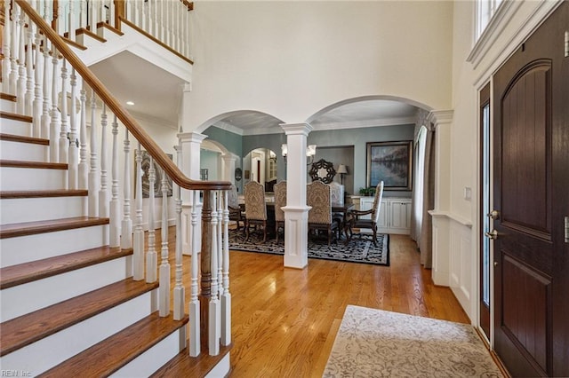 201 Glebe Spring Ln, Yorktown, VA 23693 - foyer featuring a towering ceiling, arched walkways, stairs, light wood-style flooring, and ornamental molding