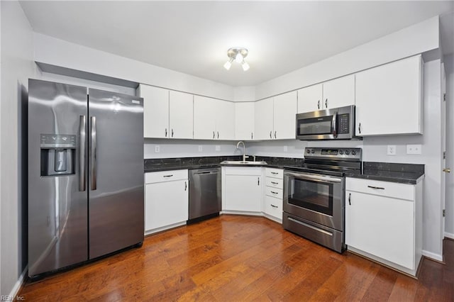 563 Seahorse Run, Chesapeake, VA 23320 - kitchen featuring appliances with stainless steel finishes, dark countertops, dark wood-style flooring, and white cabinetry