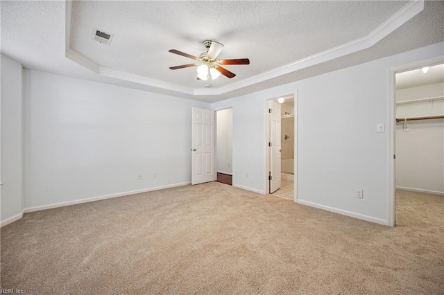563 Seahorse Run, Chesapeake, VA 23320 - unfurnished bedroom featuring a tray ceiling, a textured ceiling, a walk in closet, carpet flooring, and a closet