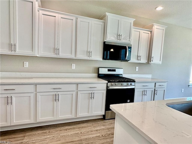 4472 Old Princess Anne Rd, Virginia Beach, VA 23462 - kitchen featuring stainless steel appliances, white cabinetry, light wood-style flooring, light stone countertops, and a textured ceiling