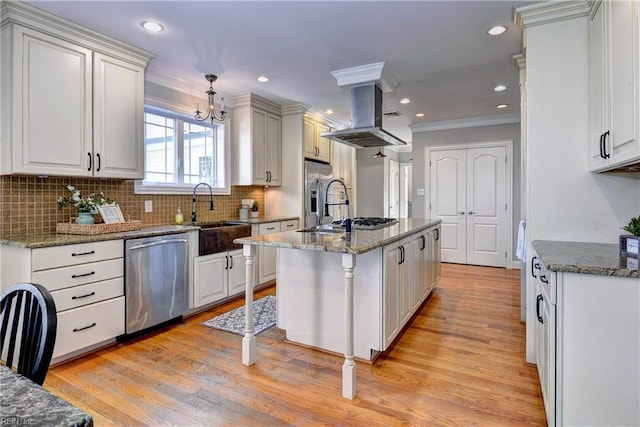 66 Heron Harbor Way, Hudgins, VA 23076 - kitchen with stainless steel appliances, ornamental molding, island range hood, light wood-style flooring, and tasteful backsplash