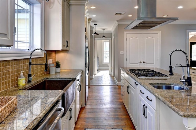 66 Heron Harbor Way, Hudgins, VA 23076 - kitchen with island exhaust hood, ornamental molding, appliances with stainless steel finishes, tasteful backsplash, and dark wood finished floors
