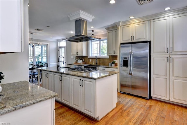 66 Heron Harbor Way, Hudgins, VA 23076 - kitchen featuring appliances with stainless steel finishes, island exhaust hood, a chandelier, a center island with sink, and light wood-style floors