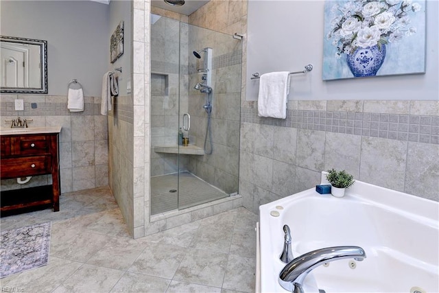 66 Heron Harbor Way, Hudgins, VA 23076 - bathroom with tile walls, a stall shower, a jetted tub, vanity, and wainscoting