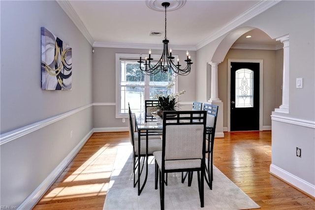 66 Heron Harbor Way, Hudgins, VA 23076 - dining area with arched walkways, ornate columns, a chandelier, light wood-type flooring, and ornamental molding