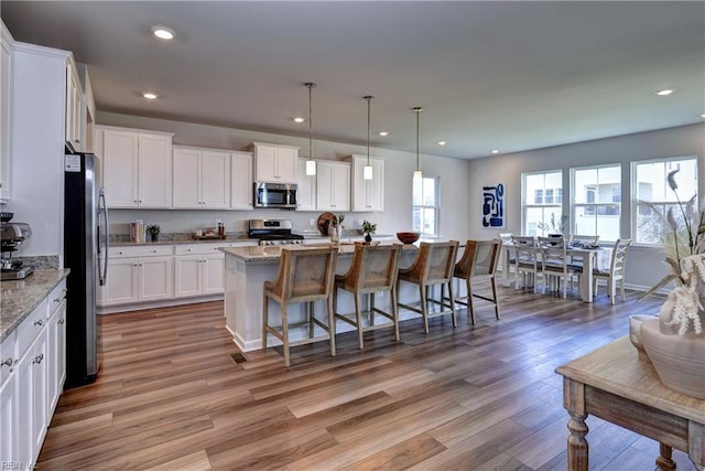 9116 Daydreamer Ct, Toano, VA 23168 - kitchen featuring stainless steel appliances, white cabinetry, light wood finished floors, a kitchen breakfast bar, and recessed lighting