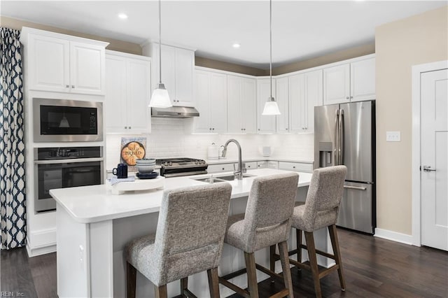 1508 Charlie St, Chesapeake, VA 23322 - kitchen featuring appliances with stainless steel finishes, dark wood-style floors, tasteful backsplash, a kitchen island with sink, and hanging light fixtures