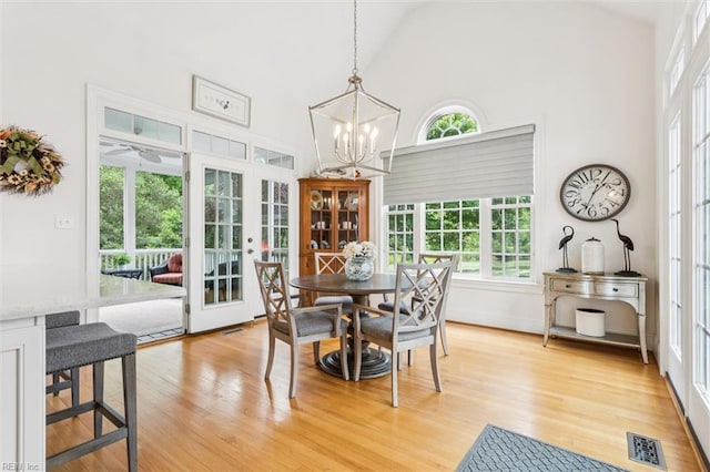 2841 Bennetts Pond Rd, Williamsburg, VA 23185 - dining room with healthy amount of natural light, french doors, light wood-style flooring, high vaulted ceiling, and a chandelier