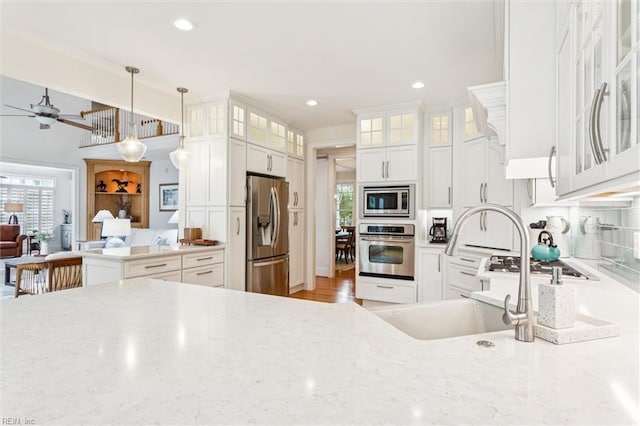 2841 Bennetts Pond Rd, Williamsburg, VA 23185 - kitchen featuring appliances with stainless steel finishes, white cabinets, ceiling fan, light stone countertops, and hanging light fixtures
