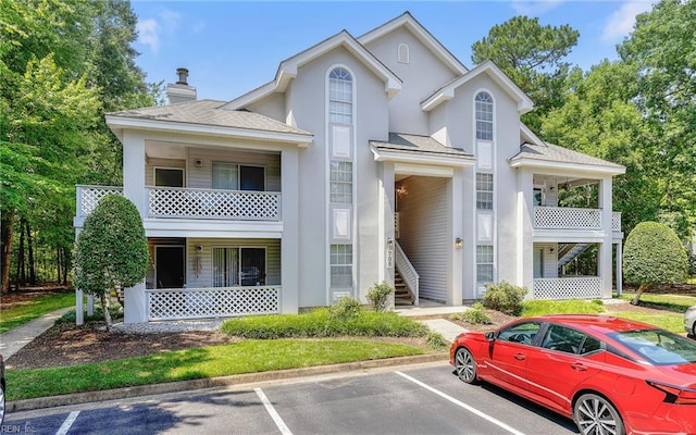 708 Inlet Quay Quay Unit D, Chesapeake, VA 23320 - view of front of home with a balcony, uncovered parking, covered porch, roof with shingles, and stucco siding