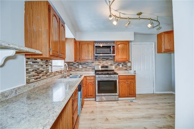 831 Quail Ave, Chesapeake, VA 23324 - kitchen with stainless steel appliances, brown cabinetry, light wood-style floors, and tasteful backsplash