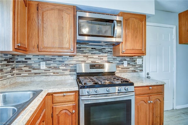 831 Quail Ave, Chesapeake, VA 23324 - kitchen featuring stainless steel appliances, backsplash, wood finished floors, and light stone counters