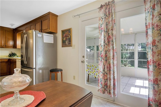 106 Deep Water Cv, Newport News, VA 23606 - kitchen featuring freestanding refrigerator, healthy amount of natural light, light tile patterned floors, and brown cabinets