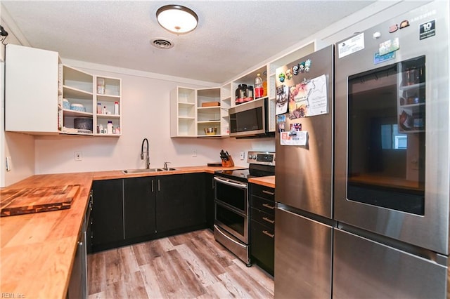 2813 Squire Ct, Chesapeake, VA 23323 - kitchen with wood counters, stainless steel appliances, open shelves, dark cabinetry, and light wood-type flooring