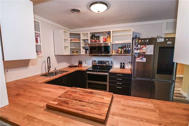 2813 Squire Ct, Chesapeake, VA 23323 - kitchen with butcher block countertops, appliances with stainless steel finishes, open shelves, a textured ceiling, and dark cabinets