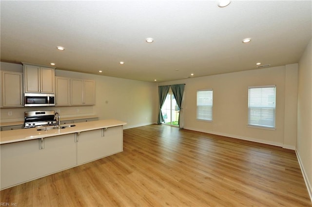 1604 Redwing Arch, Chesapeake, VA 23323 - kitchen with appliances with stainless steel finishes, light countertops, recessed lighting, light wood-style floors, and a kitchen bar
