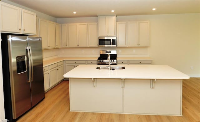 1604 Redwing Arch, Chesapeake, VA 23323 - kitchen with appliances with stainless steel finishes, recessed lighting, light wood-style flooring, a breakfast bar, and an island with sink